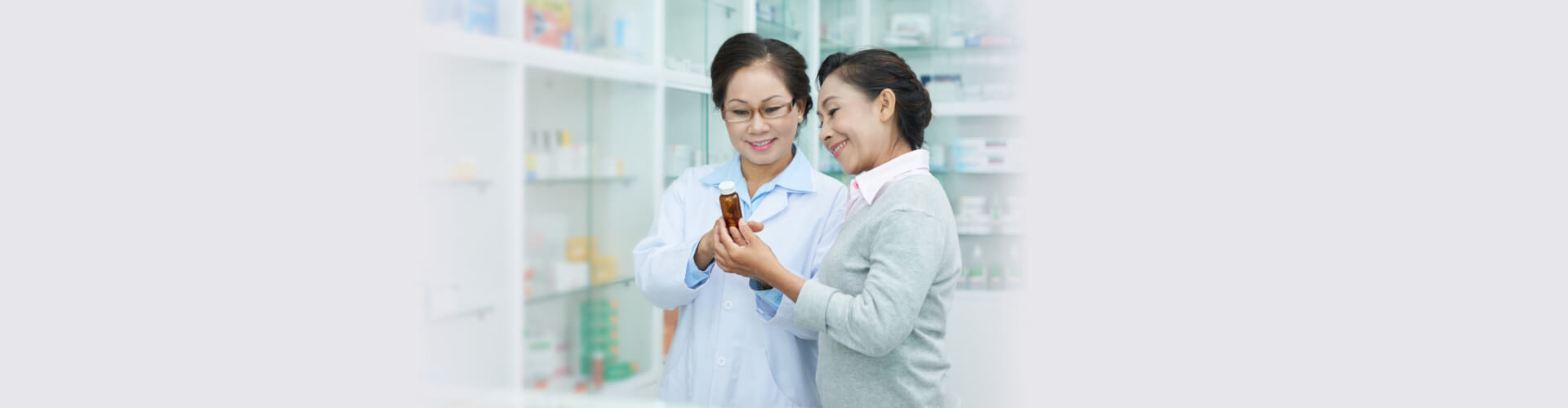 customer holding medicine beside pharmacist